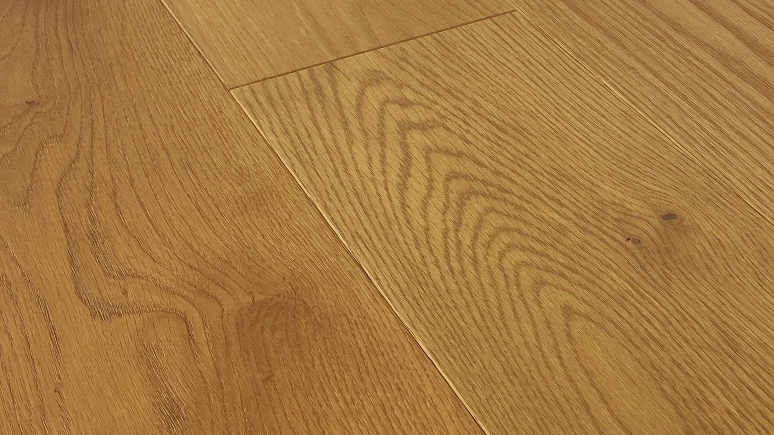 Close-up of Monarch Plank Lago Belviso European oak flooring at a low angle, showing its grain, small knots and the seams between planks