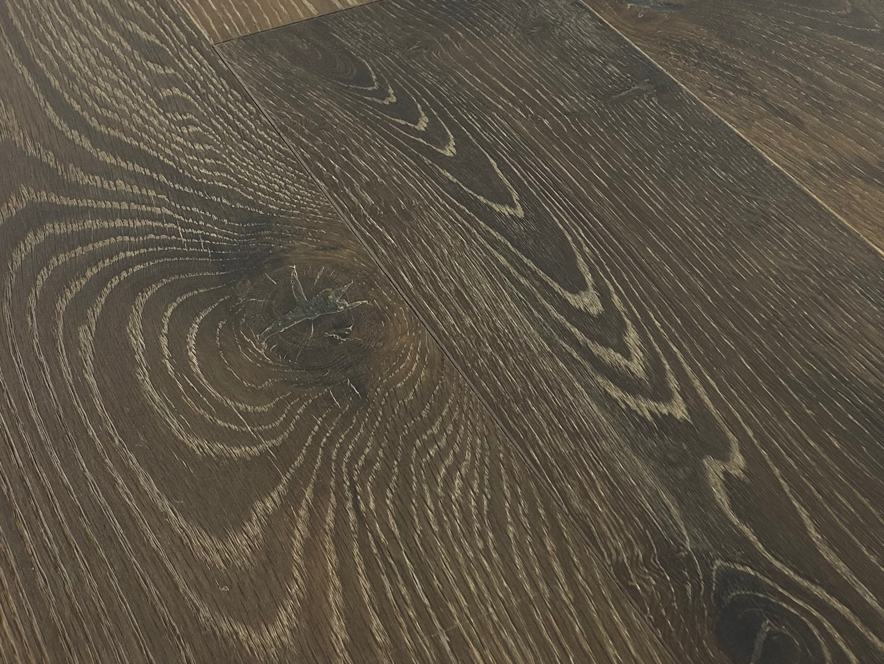 Dark wire-brushed oak with white-limed cathedral grain and a large knot