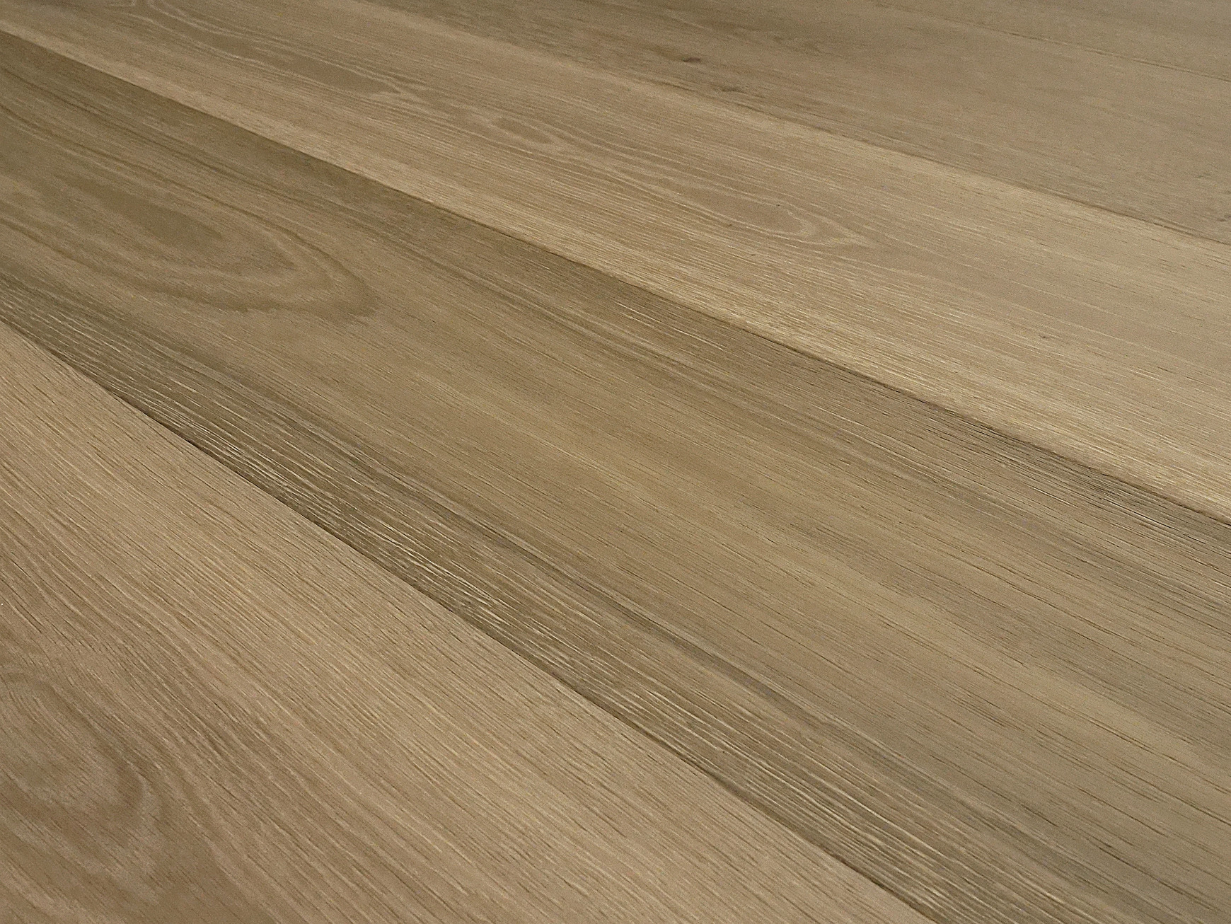 Low-angle close-up of wire-brushed grain in a warm mid-brown, with tone changes from plank to plank